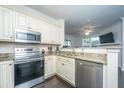 Efficient kitchen showcasing stainless steel appliances, granite countertops, and white cabinets at 130 River Landing Dr # 7123, Charleston, SC 29492