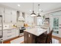 Modern kitchen featuring an island, white cabinets, stainless steel appliances, and stylish lighting at 136 Fair Sailing Rd, Mount Pleasant, SC 29466