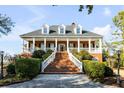 Inviting brick home featuring a grand entrance staircase, a wide porch, and manicured landscaping at 1444 Madison Ct, Mount Pleasant, SC 29466