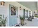 Inviting front porch featuring a decorative wreath, stylish lanterns, and comfortable seating at 1710 Sparkleberry Ln, Johns Island, SC 29455