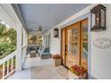 Inviting front porch featuring comfortable seating and a stylish ceiling fan at 23 Edgewater Aly, Isle of Palms, SC 29451