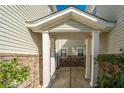 Inviting entryway with brick accents and white pillars, creating a warm transition between townhomes at 5150 Trump # 1904, North Charleston, SC 29420