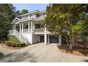 Beautiful two-story home with a charming porch, ground level garage, and meticulously maintained grounds at 707 Glossy Ibis Ln, Kiawah Island, SC 29455