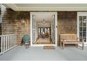 Inviting porch leading to a beautifully decorated interior with wood floors and a chandelier at 707 Glossy Ibis Ln, Kiawah Island, SC 29455