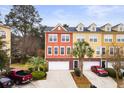 Aerial view showcasing colorful townhomes, private driveways, and mature landscaping under a blue sky at 9309 Sweetbay Ct, Ladson, SC 29456