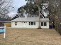 Charming single-story home featuring a metal roof, complemented by mature trees and an inviting front lawn at 1508 Greenbay Dr, North Charleston, SC 29406