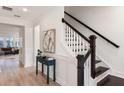 Bright entryway with wood floors, elegant staircase, stylish table and accent art at 1669 Farmers Way, Mount Pleasant, SC 29466