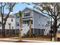 Inviting coastal home featuring a raised foundation and classic architectural details, surrounded by lush landscaping at 1669 Farmers Way, Mount Pleasant, SC 29466