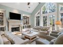 Bright living room featuring high ceilings, a fireplace, and large windows overlooking the outdoors at 2455 The Haul Over, Seabrook Island, SC 29455