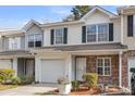 Exterior view of a townhome with a one-car garage, tidy landscaping, and neutral siding and green shutters at 250 Xavier St, Charleston, SC 29414