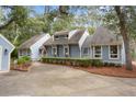 Charming light blue home featuring mature trees, manicured shrubbery, and a long driveway for ample parking at 2653 Seabrook Island Rd, Seabrook Island, SC 29455