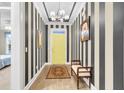 Bright entryway featuring striking striped wallpaper, beautiful wood floors, and stylish decor at 3115 Cross Vine Ln, Summerville, SC 29483