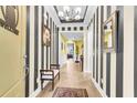 Elegant foyer with striped wallpaper, wood floors, a chandelier, and a view into other living spaces at 3115 Cross Vine Ln, Summerville, SC 29483