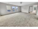 Open living room with neutral walls, plush carpet, and natural light from three large windows at 332 Cicadas Song Dr, Moncks Corner, SC 29461