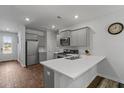 Bright kitchen boasts quartz countertops, stainless steel appliances, gray cabinets, and wood-look floors at 350 Bering Ln, Summerville, SC 29486