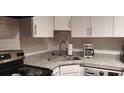 Modern kitchen featuring granite countertops, stainless steel appliances, and sleek white cabinetry at 40 Bee St # 112, Charleston, SC 29403
