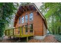Charming two-story log cabin featuring a cozy deck nestled among lush greenery at 415 W Carolina Ave, Summerville, SC 29483