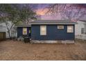 Backyard featuring potential with blue siding and minimal landscaping, under a colorful dusk sky at 4530 Holly St, North Charleston, SC 29405