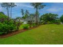 Two-story home with an attached garage, lush landscaping, and mature trees at 616 W 2Nd N St, Summerville, SC 29483