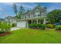 Inviting two-story home with a well-maintained lawn, attached garage, and a basketball hoop at 616 W 2Nd N St, Summerville, SC 29483