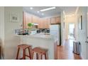 Bright kitchen with wooden cabinets, white appliances, and breakfast bar with stools at 949 E Estates Blvd # 303, Charleston, SC 29414