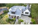 Aerial view of the stunning home showcasing its metal roof, lush surroundings, and spacious driveway at 10 Broughton Rd, Charleston, SC 29407