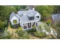 Aerial view of the stunning home showcasing its metal roof, front porch and lush, green surroundings at 10 Broughton Rd, Charleston, SC 29407