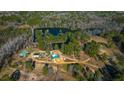 Birds eye view of acreage with several buildings, a pond and trees, providing a serene setting at 120 Rancho Hippey Way, Saint George, SC 29477