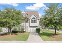 Two-story home with a white garage door and an arched window on the second floor at 1415 Widows Ct, Johns Island, SC 29455