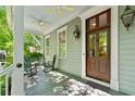 Inviting front porch with ceiling fans, rocking chairs, and classic wood door at 145 Jakes Ln, Mount Pleasant, SC 29464