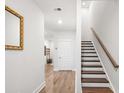 Bright foyer featuring hardwood floors, white walls, stairs and accent mirror at 1510 Martel St, Mount Pleasant, SC 29464