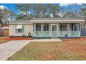 Charming home featuring a screened front porch with white picket railing, and a lawn at 1618 Yost Ln, Johns Island, SC 29455