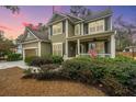 Inviting two-story home with a covered front porch and lush greenery surrounding the property at 206 President Cir, Summerville, SC 29483