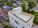 Exterior shot of a home with a rooftop patio, surrounded by neighborhood greenery, highlighting outdoor possibilities at 254 Saint Philip St # B, Charleston, SC 29403