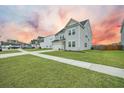 A two-story home with a well-manicured lawn and sidewalks on a partly cloudy day at 296 Firewheel Ct, Summerville, SC 29486
