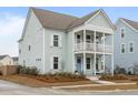 A charming two-story home with a double porch in a neighborhood of homes, and a landscaped yard at 46 Clearblue Loop, Summerville, SC 29486
