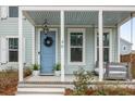 Cozy front porch features a blue front door, a swing, and tasteful landscaping at 46 Clearblue Loop, Summerville, SC 29486
