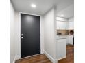 Inviting entryway with wood floors, white walls and a black door, leading to the bright kitchen at 461 Double Eagle Trce, Johns Island, SC 29455