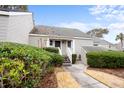 Welcoming front of townhome featuring manicured bushes, a walkway, and outdoor lighting at 461 Double Eagle Trce, Johns Island, SC 29455