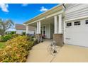 Inviting front porch with brick supports, garden and bench seating at 550 Tidewater Chase Ln, Summerville, SC 29486
