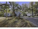 Exterior view showing the home's blue siding, guest house, and ample lot with mature landscaping at 6094 Chisolm Rd, Johns Island, SC 29455