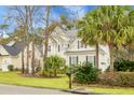 Inviting home exterior surrounded by lush landscaping, mature trees, and a well-maintained lawn at 6917 Tanner Hall Blvd, Hanahan, SC 29410