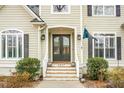 Welcoming front entrance with double doors, decorative plants, and prominent house number on the steps at 6917 Tanner Hall Blvd, Hanahan, SC 29410