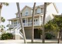Inviting home boasts a large porch, perfect for relaxing and enjoying the coastal breeze at 10 Toms Turnaround Cir, Edisto Island, SC 29438