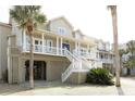 Stunning coastal home featuring elevated construction, a large porch, and ample outdoor space at 10 Toms Turnaround Cir, Edisto Island, SC 29438