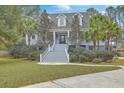 Charming two-story home with a welcoming front porch, lush landscaping, and a well-manicured lawn with mature trees at 1012 Denali Ct, Summerville, SC 29483