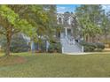 Charming two-story home with a welcoming front porch, lush landscaping, and a well-manicured lawn with mature trees at 1012 Denali Ct, Summerville, SC 29483