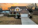 Charming two-story home with brick facade and welcoming front porch, reflecting sunset at 1106 Mccrae Dr, Moncks Corner, SC 29461