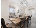 Elegant dining room featuring a modern chandelier, a wooden table set for six, and large windows at 129 Isherwood Dr, Goose Creek, SC 29445