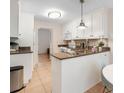 Bright kitchen featuring white cabinets, granite countertops, and tile flooring, offering a clean and efficient space at 133 Wentworth St, Charleston, SC 29401